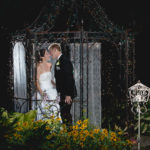 bride and groom on bridge at night