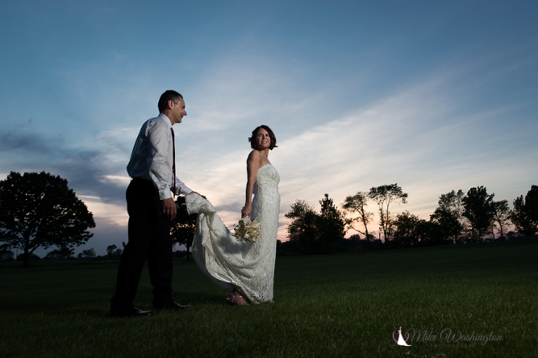 bride and groom with sun setting in background